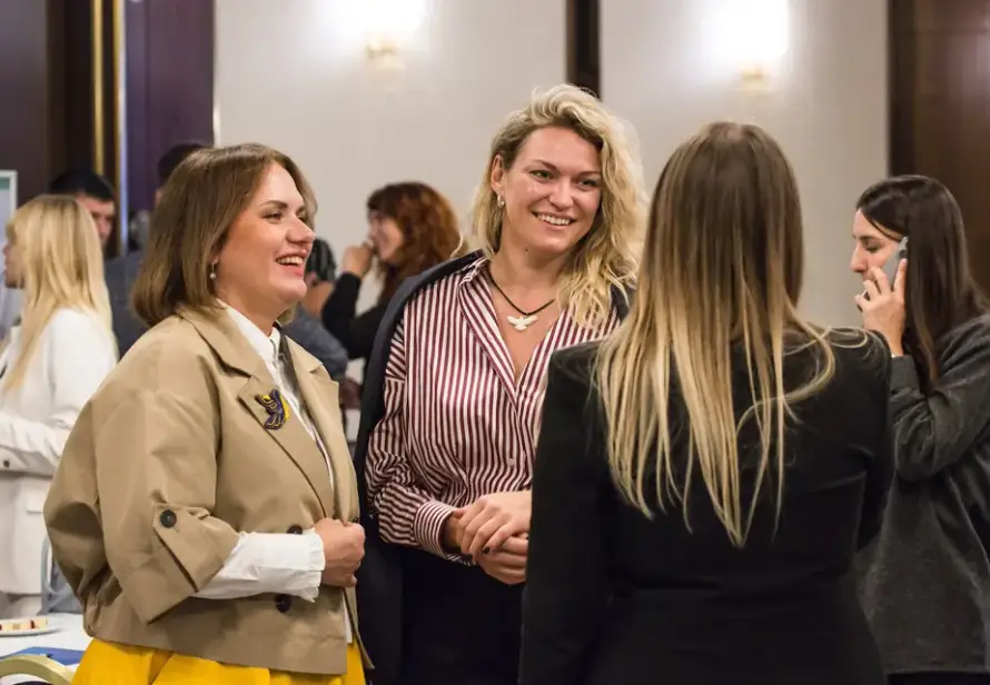 Учасниці форуму UBN спілкуються та усміхаються під час нетворкінгу